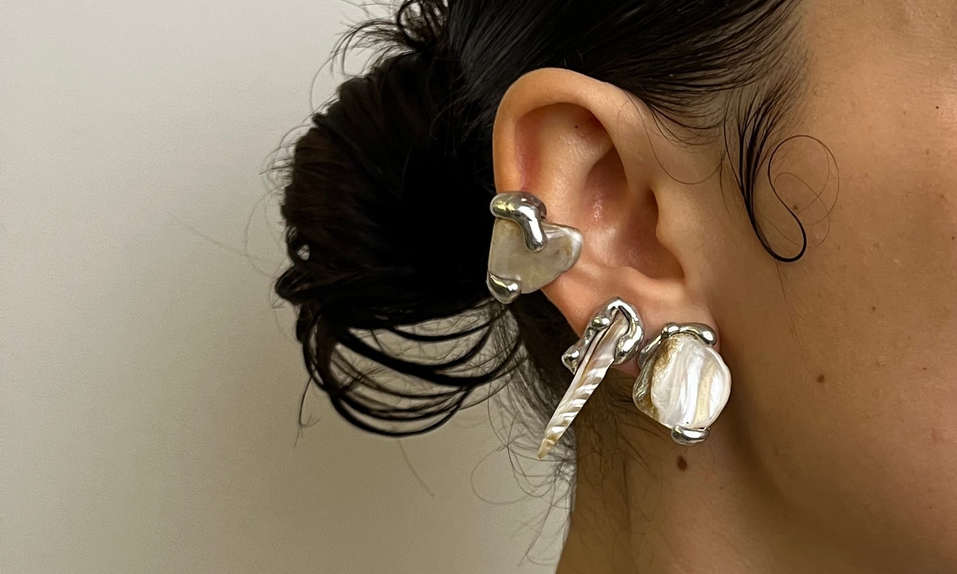 an ear stacked with silver and mother-of-pearl pieces